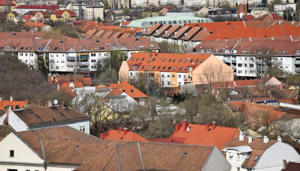 Városi kilátás: sűrűn beépített terület különböző színű és formájú háztetői.